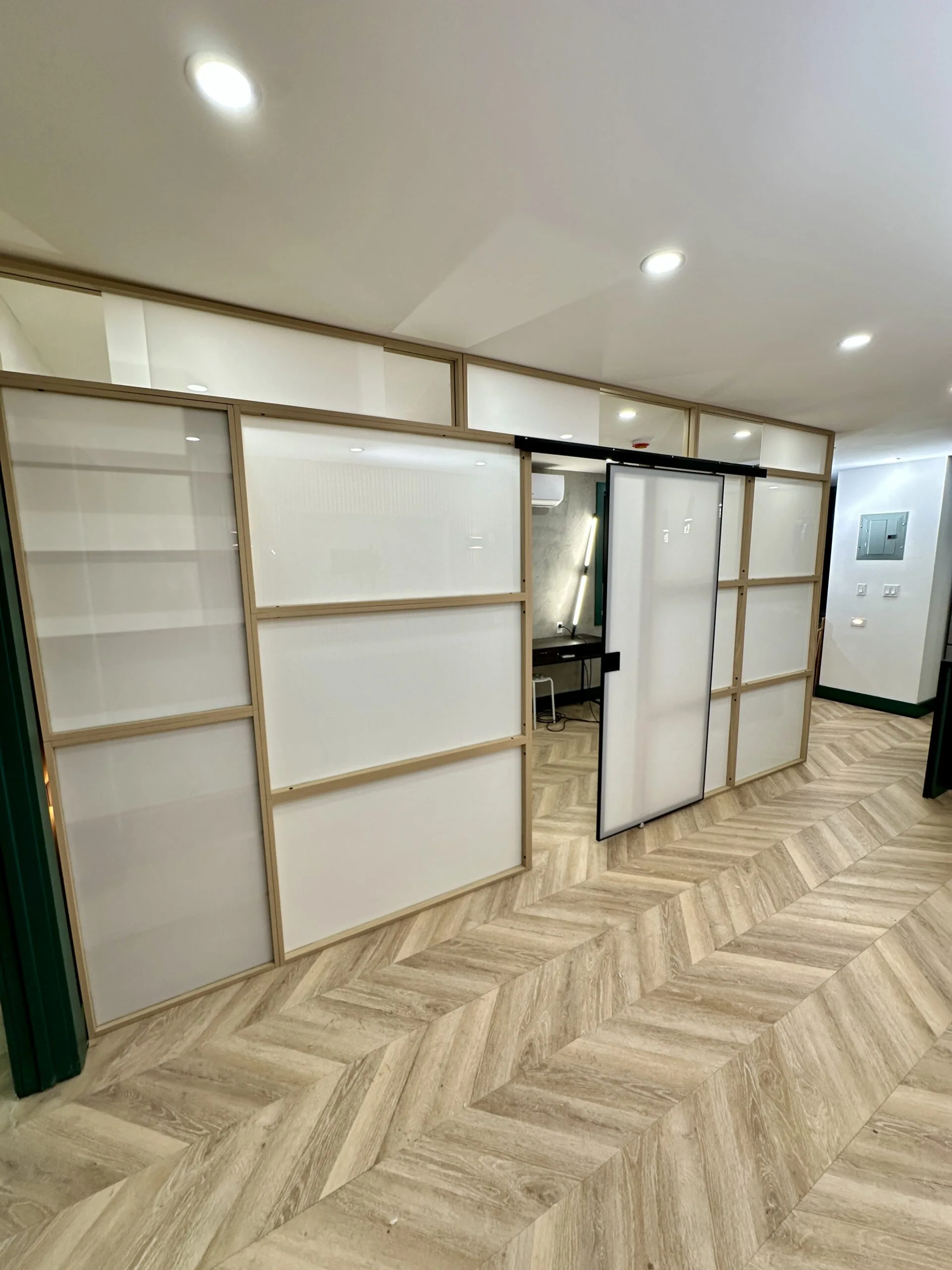 Freestanding room divider with a sliding door and windows in a Brooklyn, NY apartment