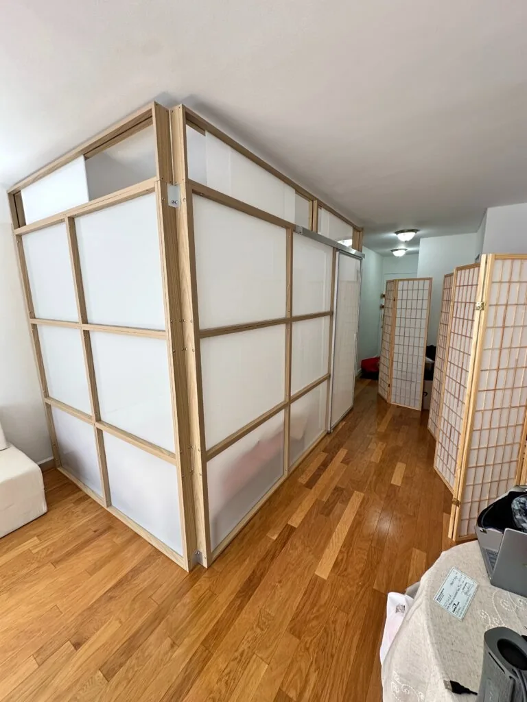Freestanding 1W2R modular divider with frosted white acrylic panels in a modern apartment
