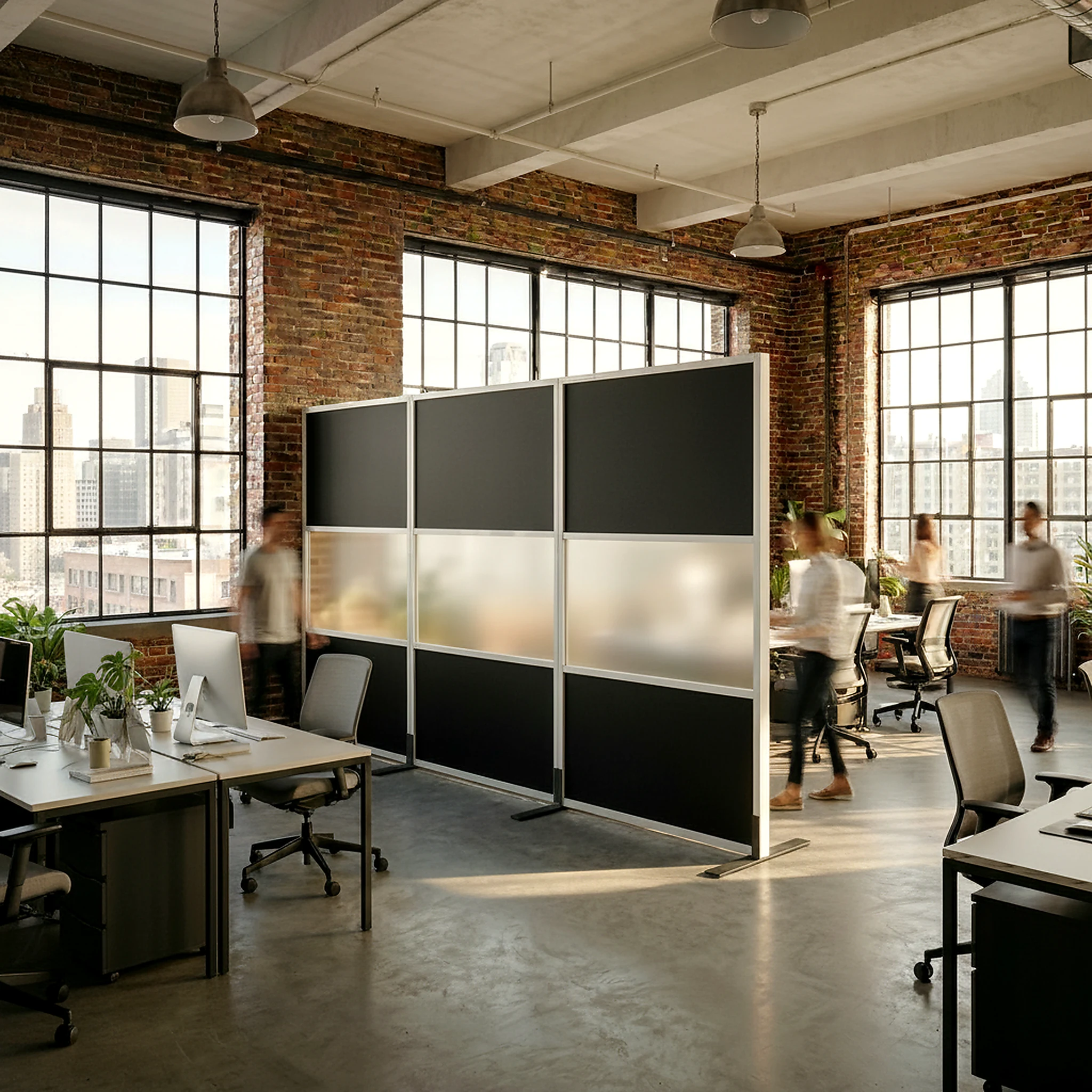 Black-frame office divider wall creating a private room in a loft office