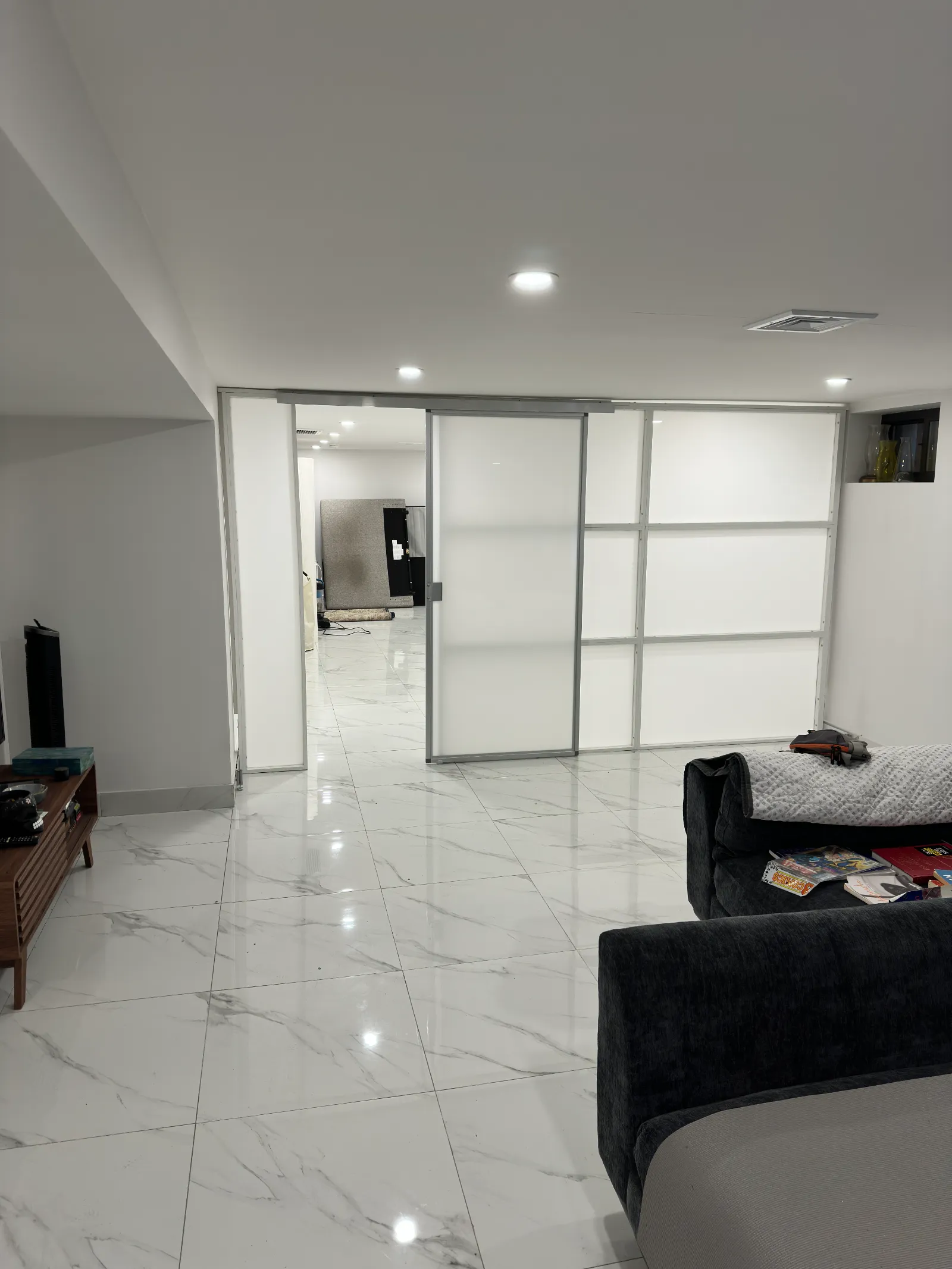 Basement room divider with the sliding door open &mdash; only the door slides, the wall stands fixed