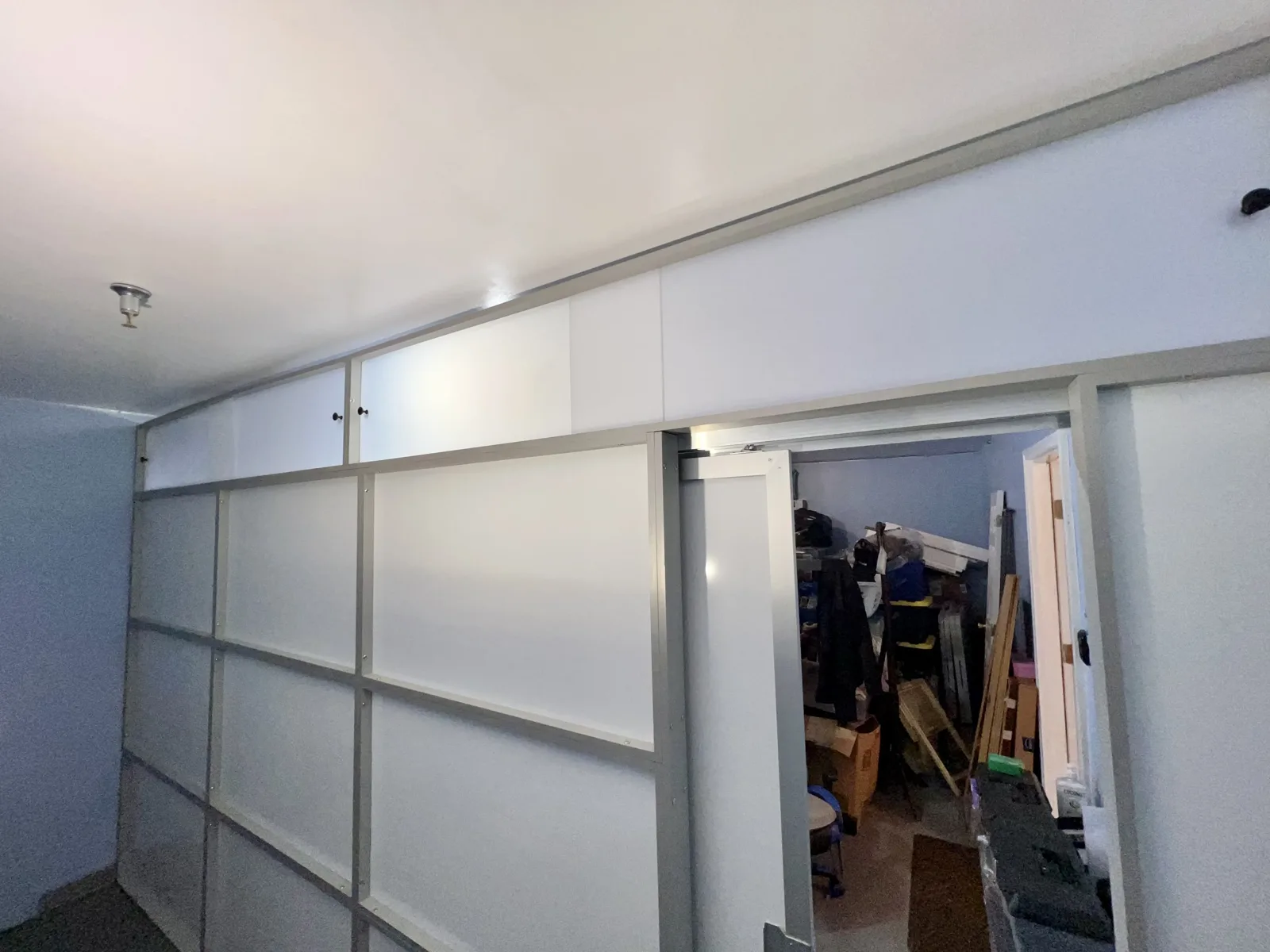 Garage divider wall with the sliding door open &mdash; storage behind the wall stays reachable